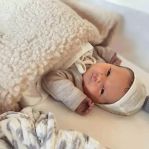 Baby onder een Flat White wiegdeken van merinowol