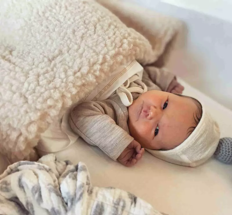 Baby onder een Flat White wiegdeken van merinowol