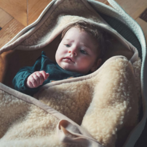 Baby gewikkeld in een Latte merinowollen wikkeldoek