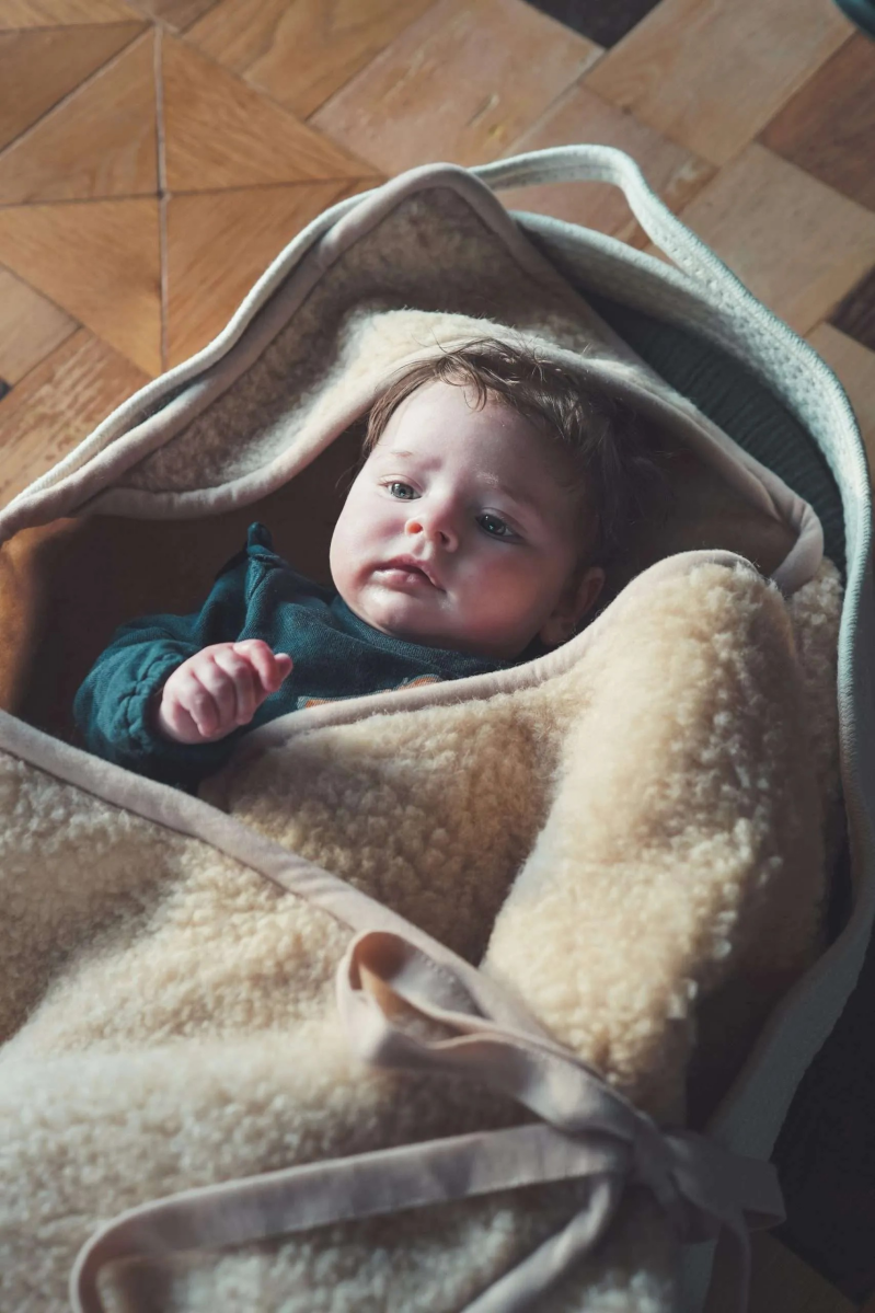 Baby gewikkeld in een Latte merinowollen wikkeldoek