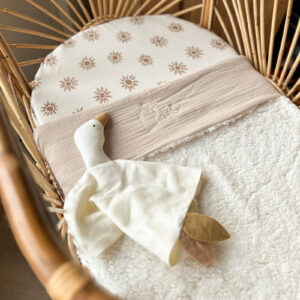 Beige teddy wiegdeken met knuffel in een rotan wieg