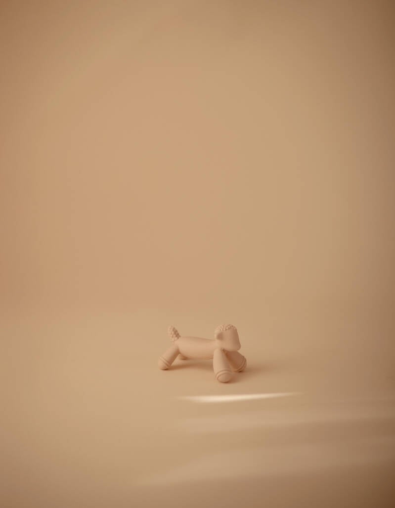 Crèmekleurige lammetje-bijtfiguur op een beige achtergrond