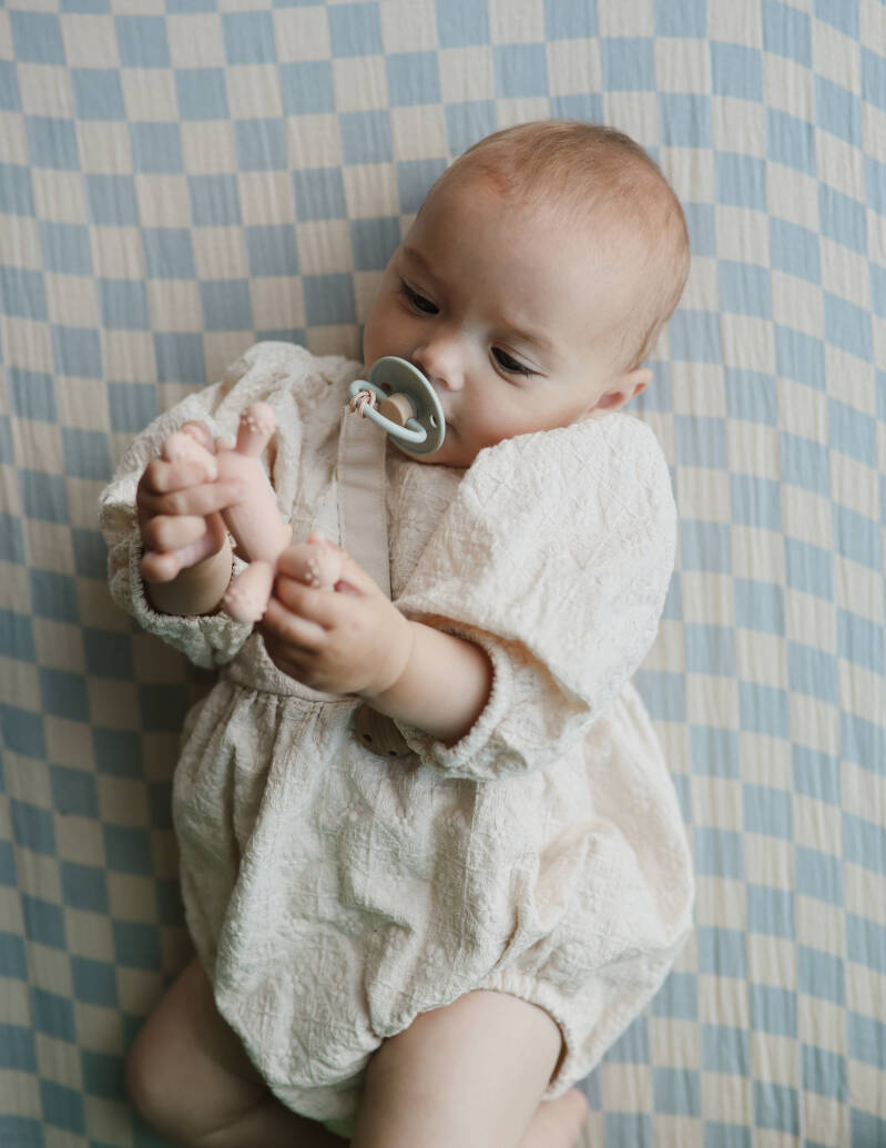 Baby speelt met een roze eenhoorn-bijtfiguur